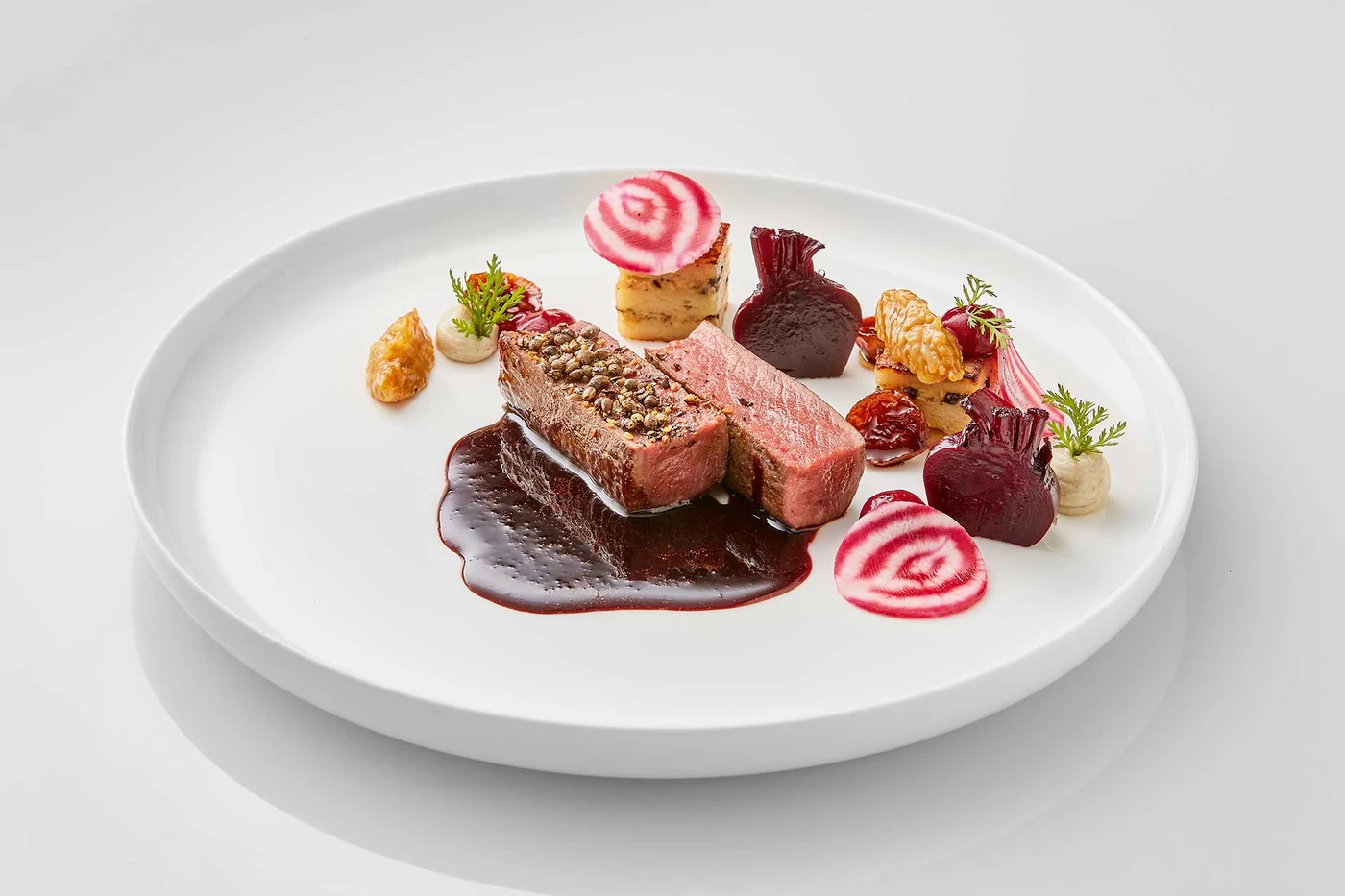 Plato con estrella Michelin de Sebastian Cihlars en el Restaurant Schattbuch – carne con corteza de pimienta, variaciones de remolacha, nuez y reducción de vino tinto